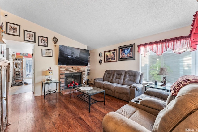 living room with a textured ceiling, a fireplace, dark hardwood / wood-style flooring, and lofted ceiling