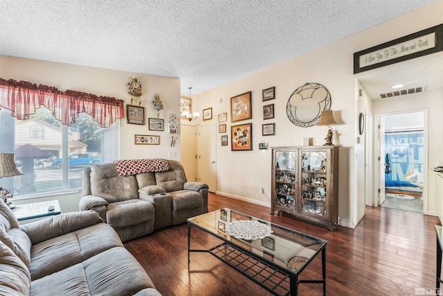 living room with a textured ceiling and dark hardwood / wood-style flooring