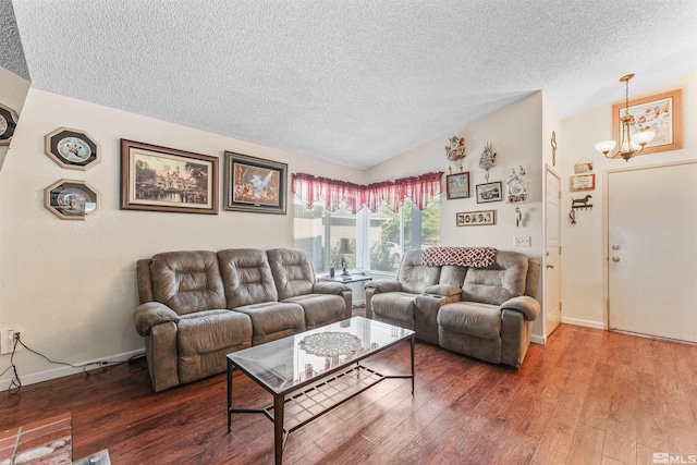 living room with a notable chandelier, vaulted ceiling, a textured ceiling, and hardwood / wood-style floors