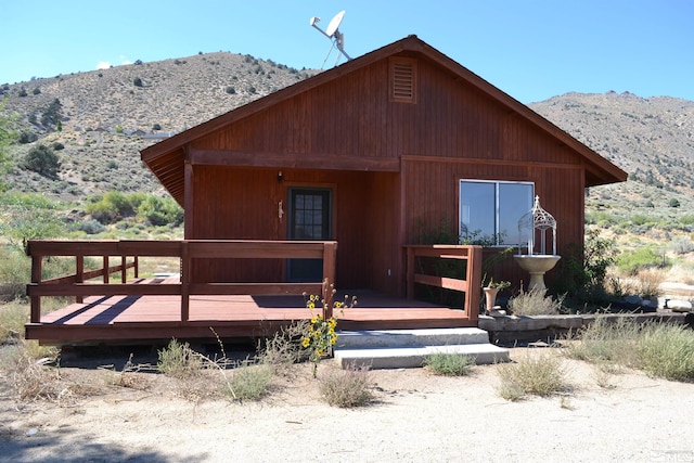 rear view of house with a deck with mountain view