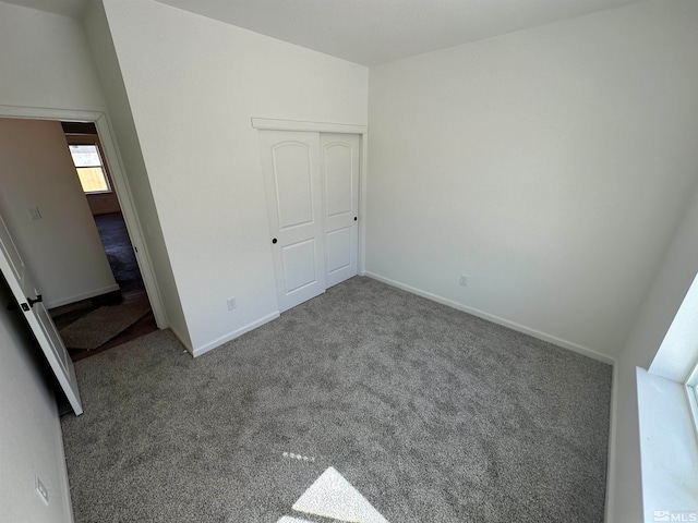 unfurnished bedroom featuring light carpet and a closet