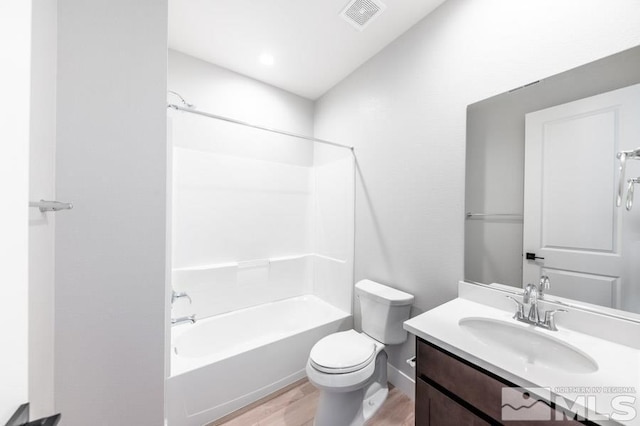 full bathroom featuring shower / bathing tub combination, hardwood / wood-style floors, vanity, and toilet