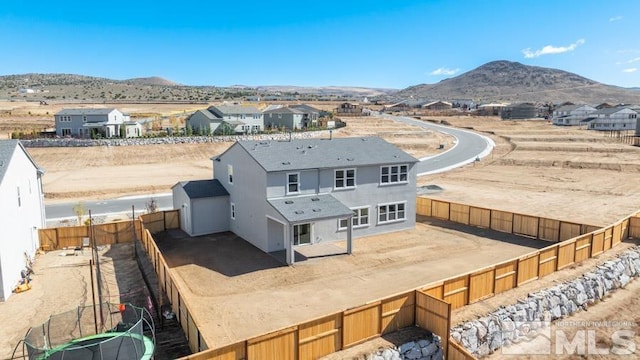 back of property featuring a mountain view and a trampoline