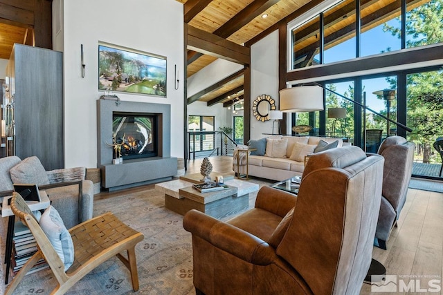 living room with beamed ceiling, light hardwood / wood-style floors, high vaulted ceiling, and wooden ceiling