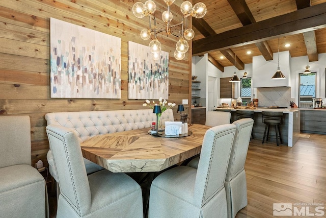 dining room with wooden walls, vaulted ceiling with beams, and hardwood / wood-style flooring