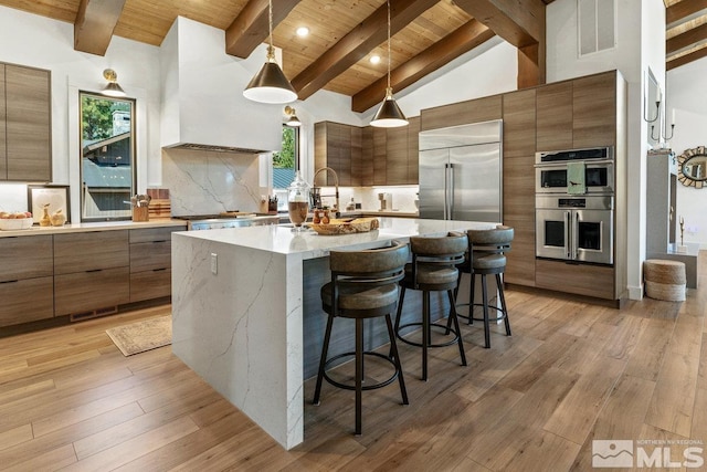 kitchen with light hardwood / wood-style floors, beamed ceiling, stainless steel appliances, decorative light fixtures, and wooden ceiling