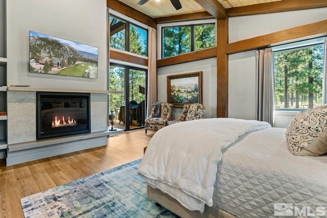 bedroom with multiple windows, wood-type flooring, and ceiling fan