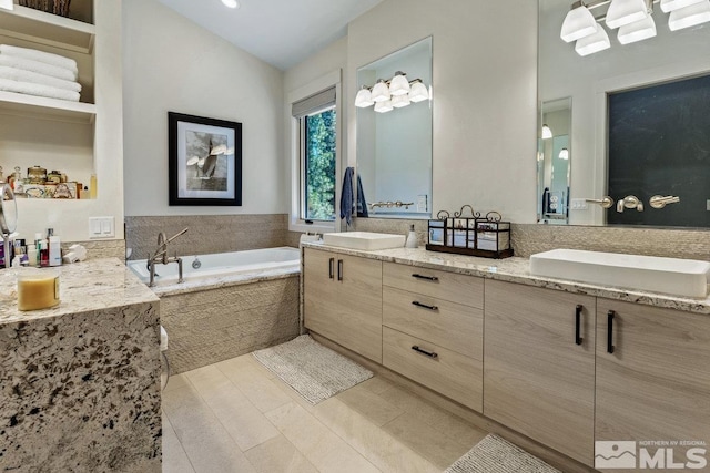 bathroom with tiled bath, vanity, and lofted ceiling