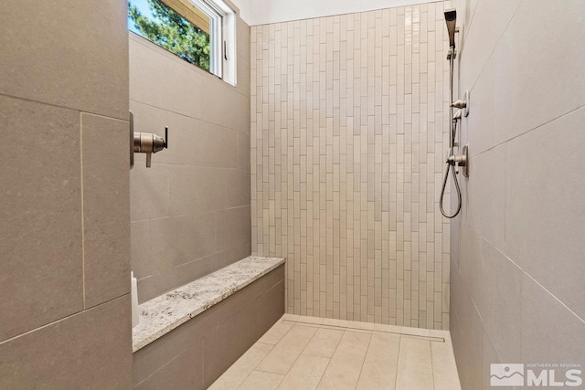 bathroom with tile patterned flooring and tiled shower