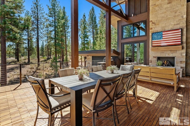 sunroom featuring an outdoor stone fireplace