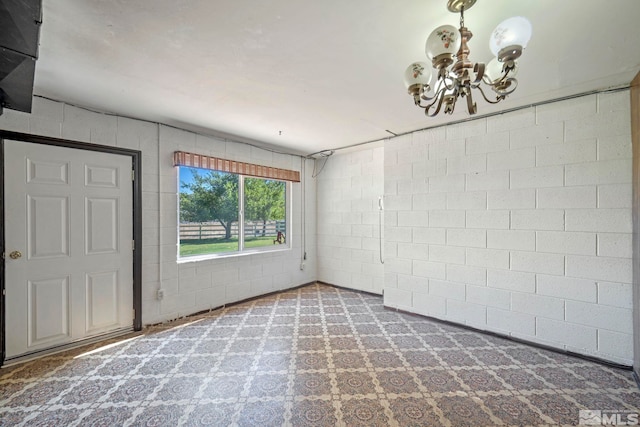 unfurnished room featuring a chandelier