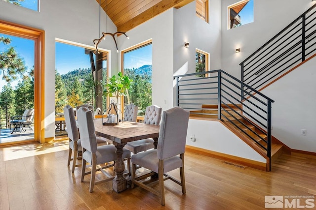 dining space featuring wooden ceiling, light hardwood / wood-style floors, and high vaulted ceiling