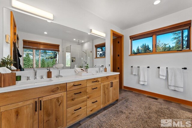 bathroom featuring a shower with door and vanity