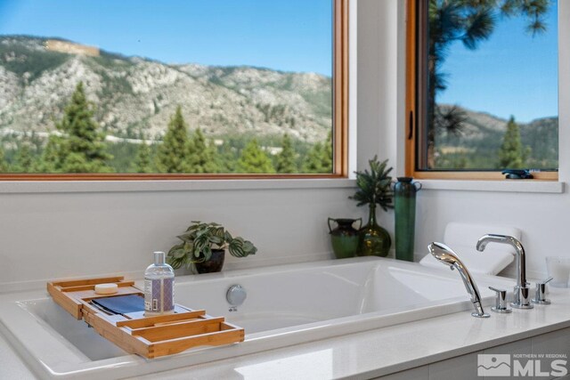 bathroom with a tub and a mountain view