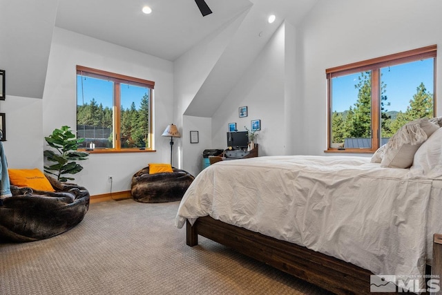 bedroom featuring multiple windows, vaulted ceiling, ceiling fan, and carpet floors