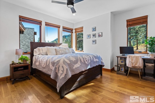 bedroom with light hardwood / wood-style floors, multiple windows, and ceiling fan