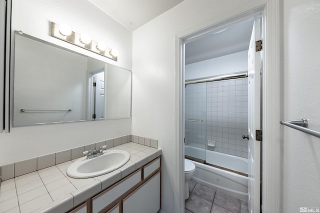 full bathroom with bath / shower combo with glass door, vanity, toilet, and tile patterned floors