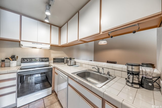 kitchen with electric range oven, dishwasher, white cabinets, and sink