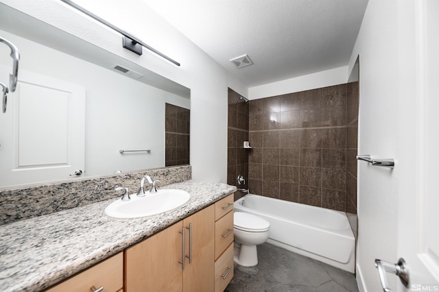 full bathroom with a textured ceiling, vanity, toilet, and tiled shower / bath