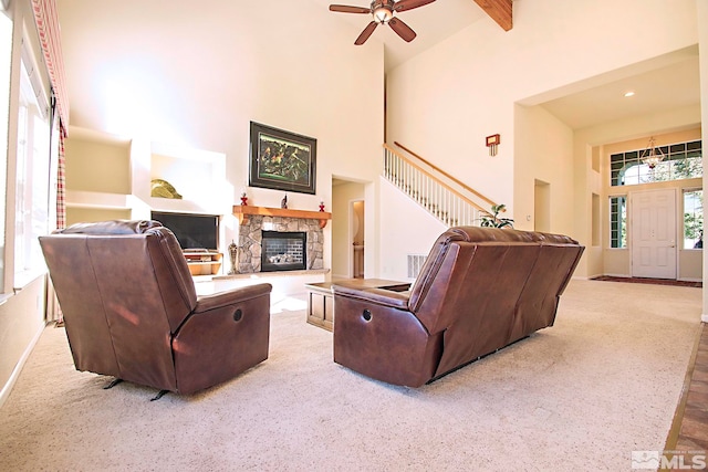 carpeted living room with a fireplace, ceiling fan, beamed ceiling, and high vaulted ceiling