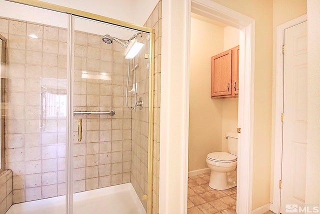 bathroom featuring a shower with door and toilet