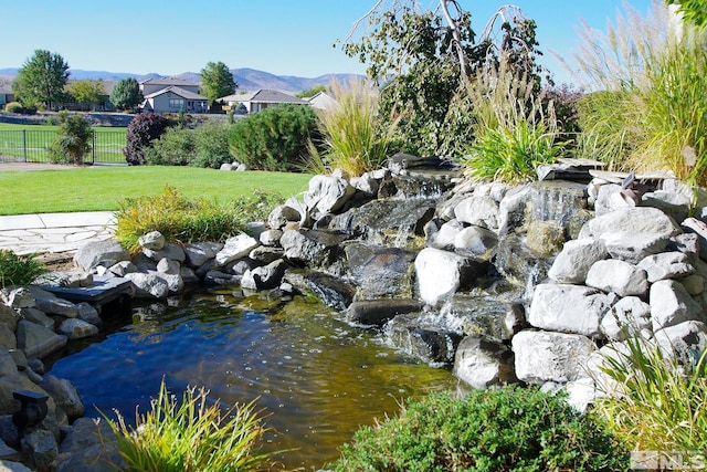 view of property's community with a mountain view and a yard