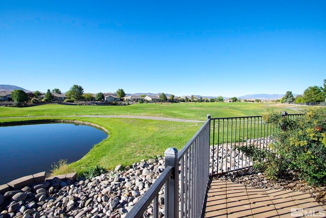 deck with a water and mountain view and a yard