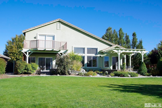 back of house with a lawn, a pergola, and a balcony