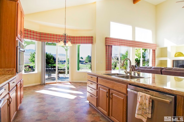 kitchen featuring hanging light fixtures, sink, stainless steel appliances, and a wealth of natural light