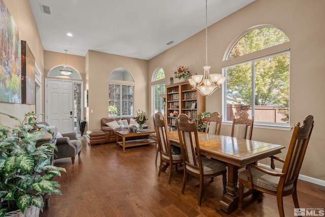 dining room with an inviting chandelier, lofted ceiling, and dark hardwood / wood-style floors