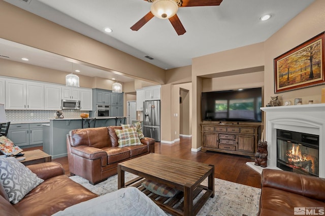 living room with dark hardwood / wood-style flooring and ceiling fan