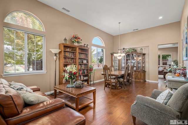 living room featuring a chandelier, dark wood-type flooring, and a wealth of natural light