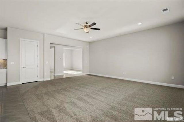 unfurnished living room featuring dark colored carpet and ceiling fan