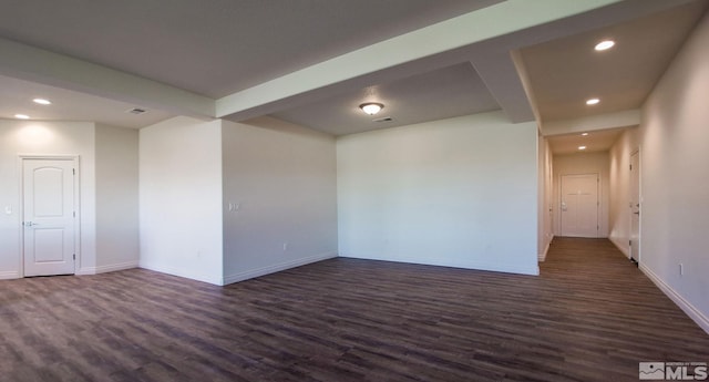 spare room featuring dark hardwood / wood-style floors and beamed ceiling