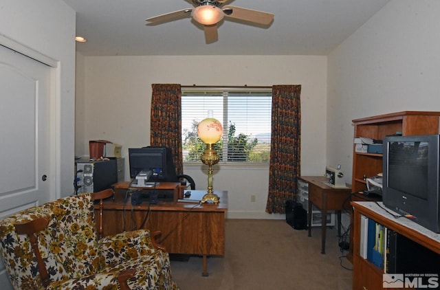 carpeted home office featuring ceiling fan