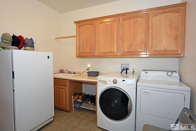 laundry room featuring light tile patterned flooring, sink, washing machine and clothes dryer, and cabinets