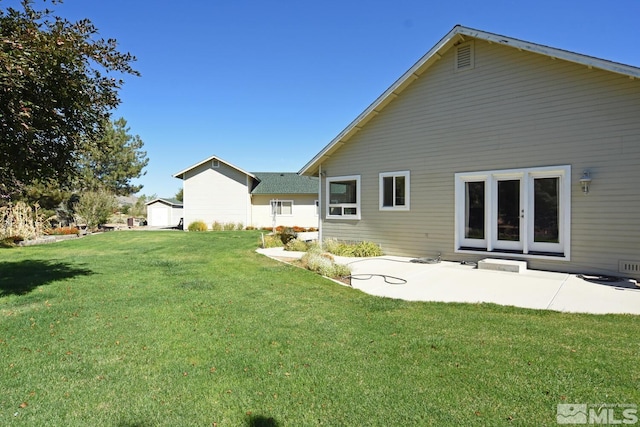 back of property featuring a storage unit, a patio, and a yard