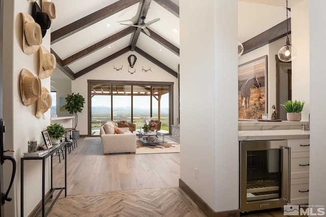 interior space with a mountain view, hardwood / wood-style flooring, beverage cooler, beam ceiling, and high vaulted ceiling