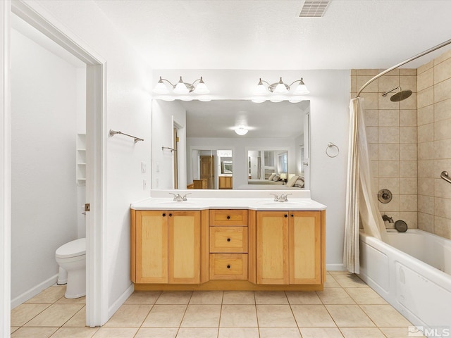 full bathroom with vanity, toilet, shower / bath combo with shower curtain, and tile patterned floors