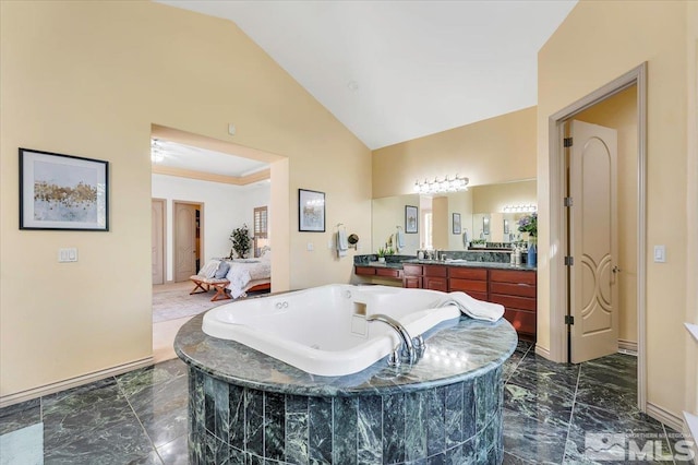 bathroom with a relaxing tiled tub, vanity, and high vaulted ceiling