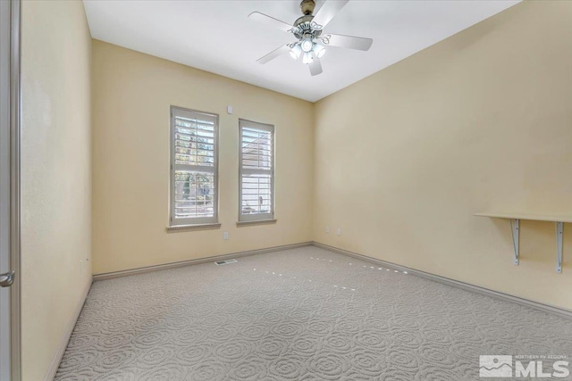 carpeted spare room with ceiling fan