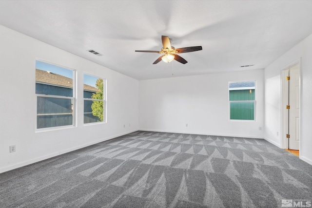 spare room with dark carpet and ceiling fan