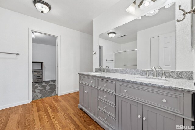 bathroom with hardwood / wood-style flooring, vanity, and a shower with shower door