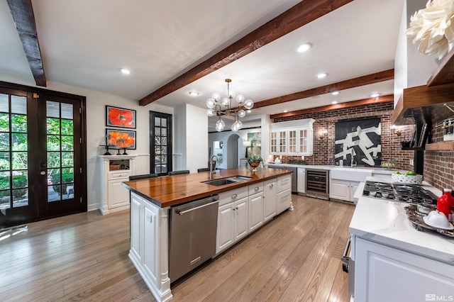 kitchen with wood counters, sink, white cabinets, stainless steel appliances, and french doors