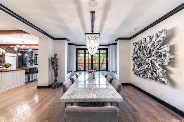 dining space with an inviting chandelier, hardwood / wood-style flooring, and ornamental molding