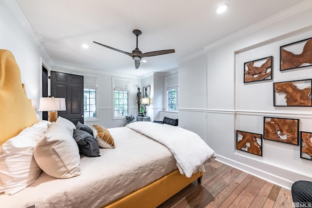 bedroom featuring wood-type flooring, ornamental molding, and ceiling fan