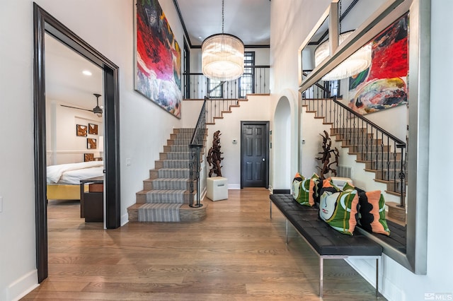 foyer featuring ceiling fan with notable chandelier and hardwood / wood-style floors