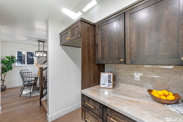 kitchen featuring dark brown cabinetry, hardwood / wood-style floors, and tasteful backsplash