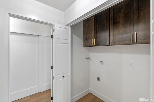 washroom featuring cabinets, electric dryer hookup, and light hardwood / wood-style flooring