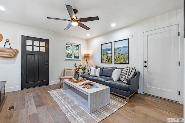 living room with ceiling fan and light hardwood / wood-style floors